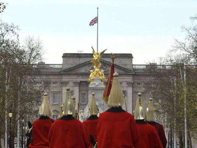 Members of the household cavalry ride down The Mall as the Union flag flies at half-mast in a mark of respect following the death of former South African President Nelson Mandela, at Buckingham Palace in London