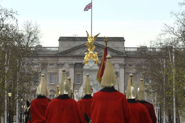 Members of the household cavalry ride down The Mall as the Union flag flies at half-mast in a mark of respect following the death of former South African President Nelson Mandela, at Buckingham Palace in London