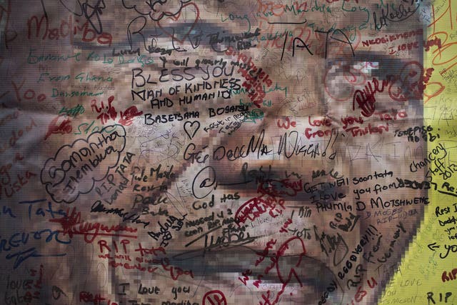A poster of Nelson Mandela on which mourners have written their messages of condolence and support, in the street outside his old house in Soweto, Johannesburg