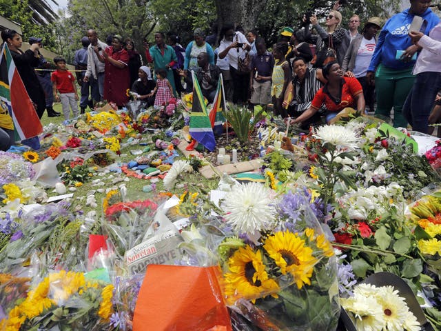 Mourners lay flowers outside the house of the late South African president Nelson Mandela in Johannesburg