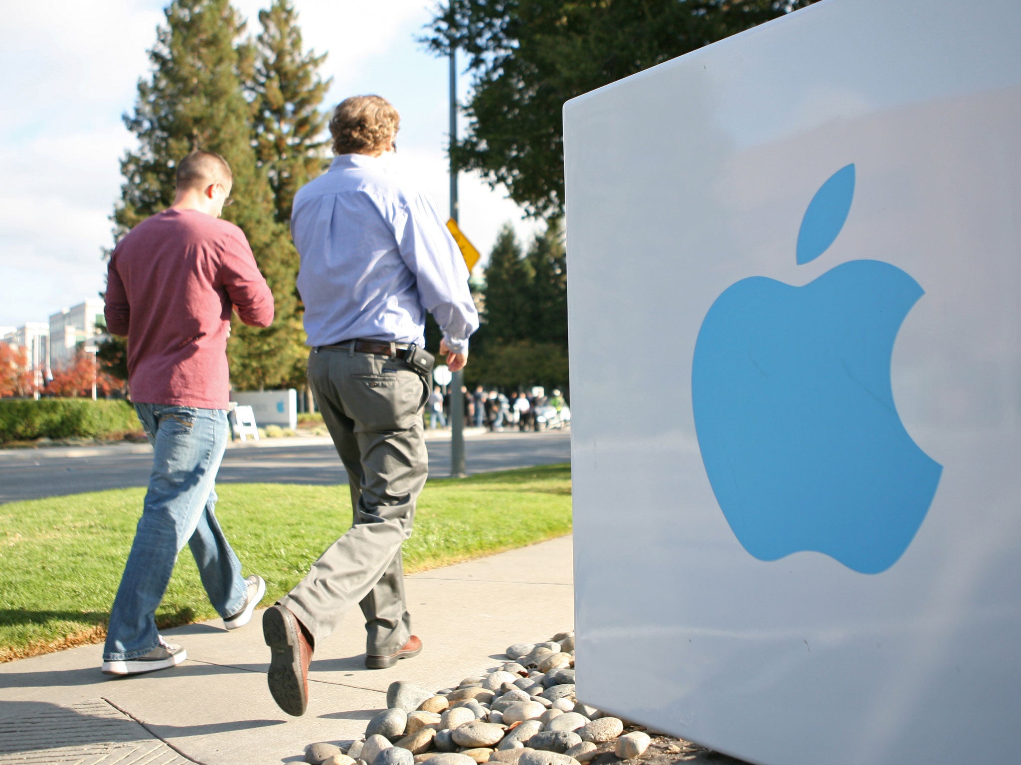 Apple employees walk towards the Apple Headquarters in Cupertino, California