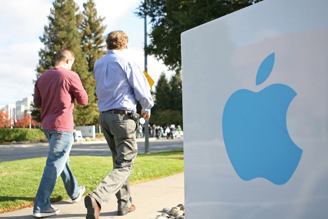 Apple employees walk towards the Apple Headquarters in Cupertino, California