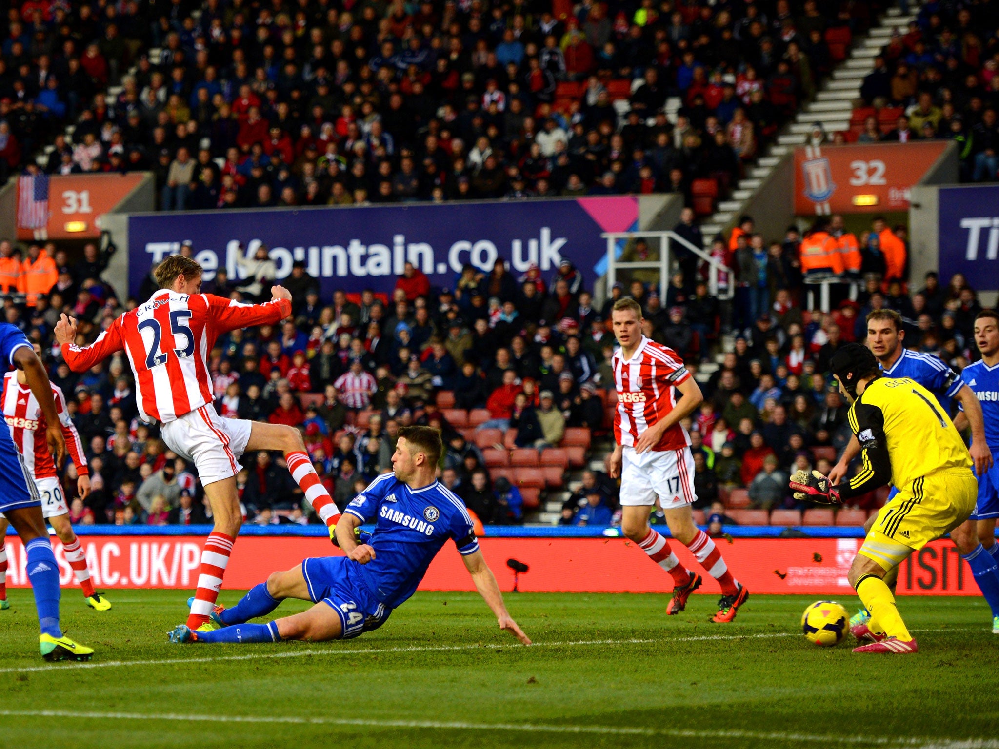 Peter Crouch of Stoke shoots past Gary Cahill of Chelsea to score a goal to level the scores