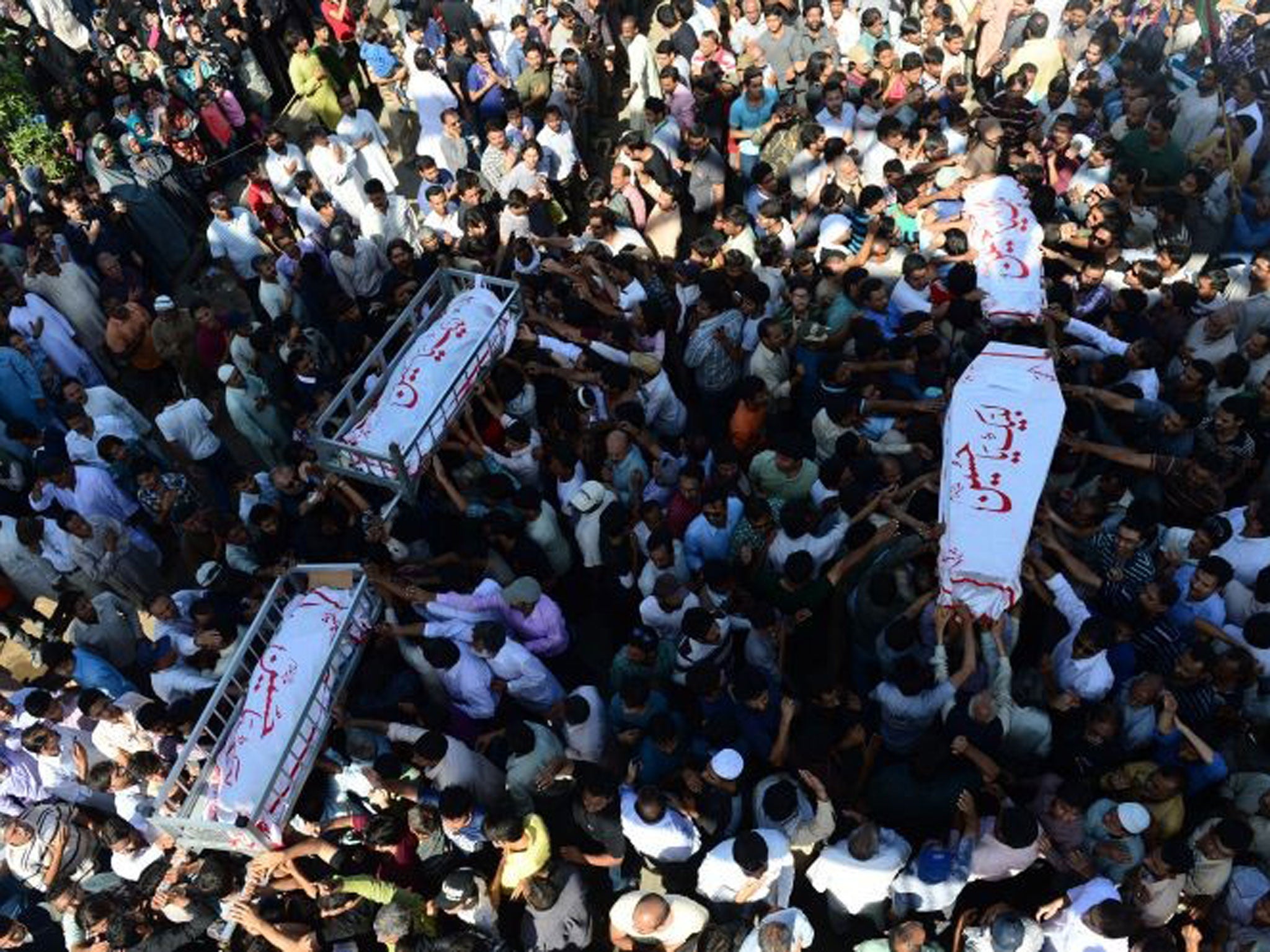 Public grief: Mass funerals after a car bomb in a Shia area of Karachi in March