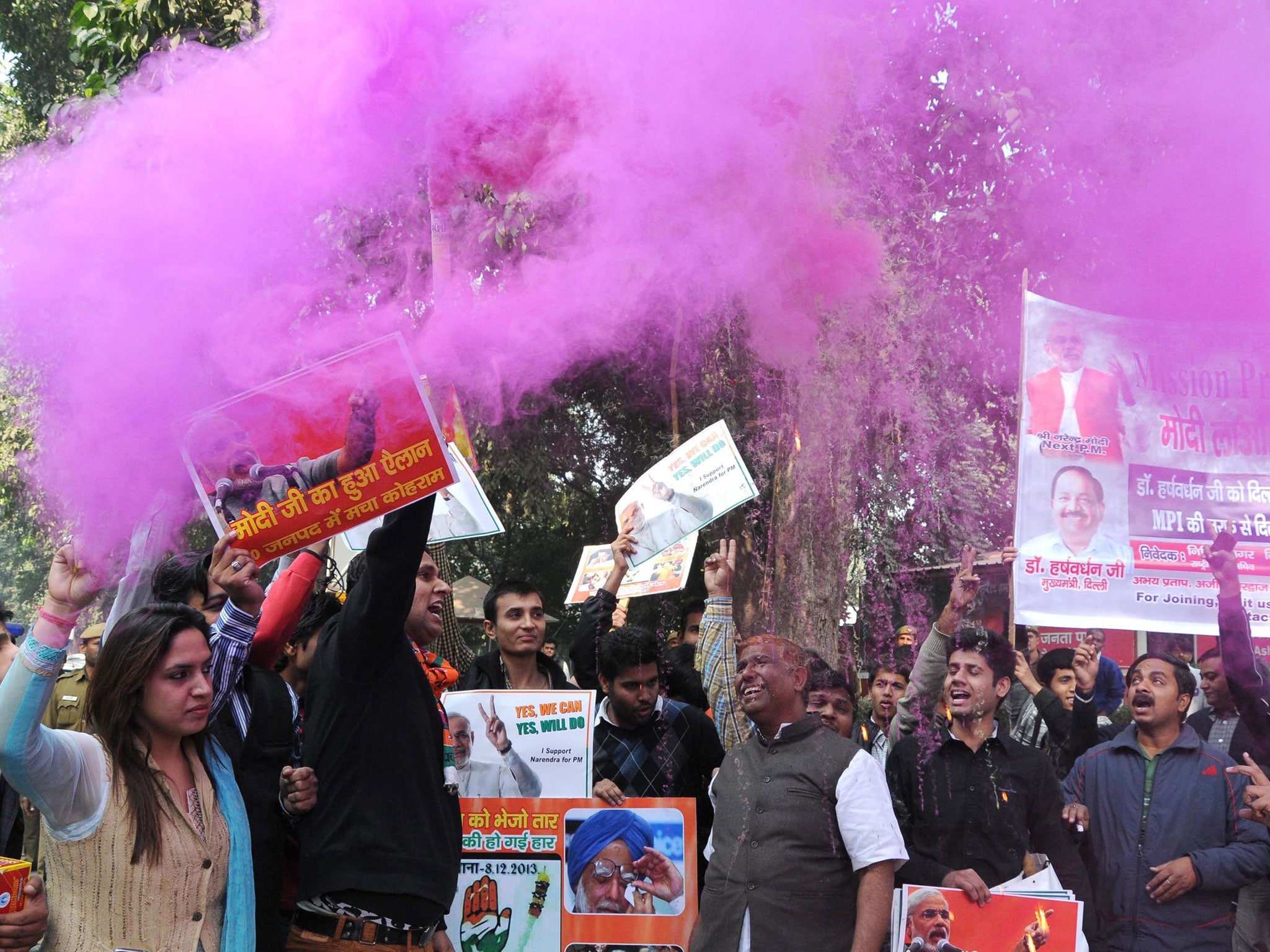 Supporters of the Indian Bharatiya Janata Party (BJP) spray color dust as they celebrate outside their party headquarter after the announcement of the results of the Assembly elections