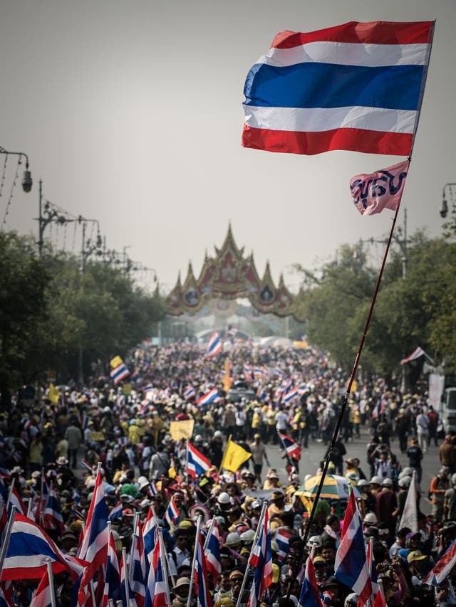 Demonstrators marching towards Government House in Bangkok; an estimated 100,000 protesters flooded the streets 