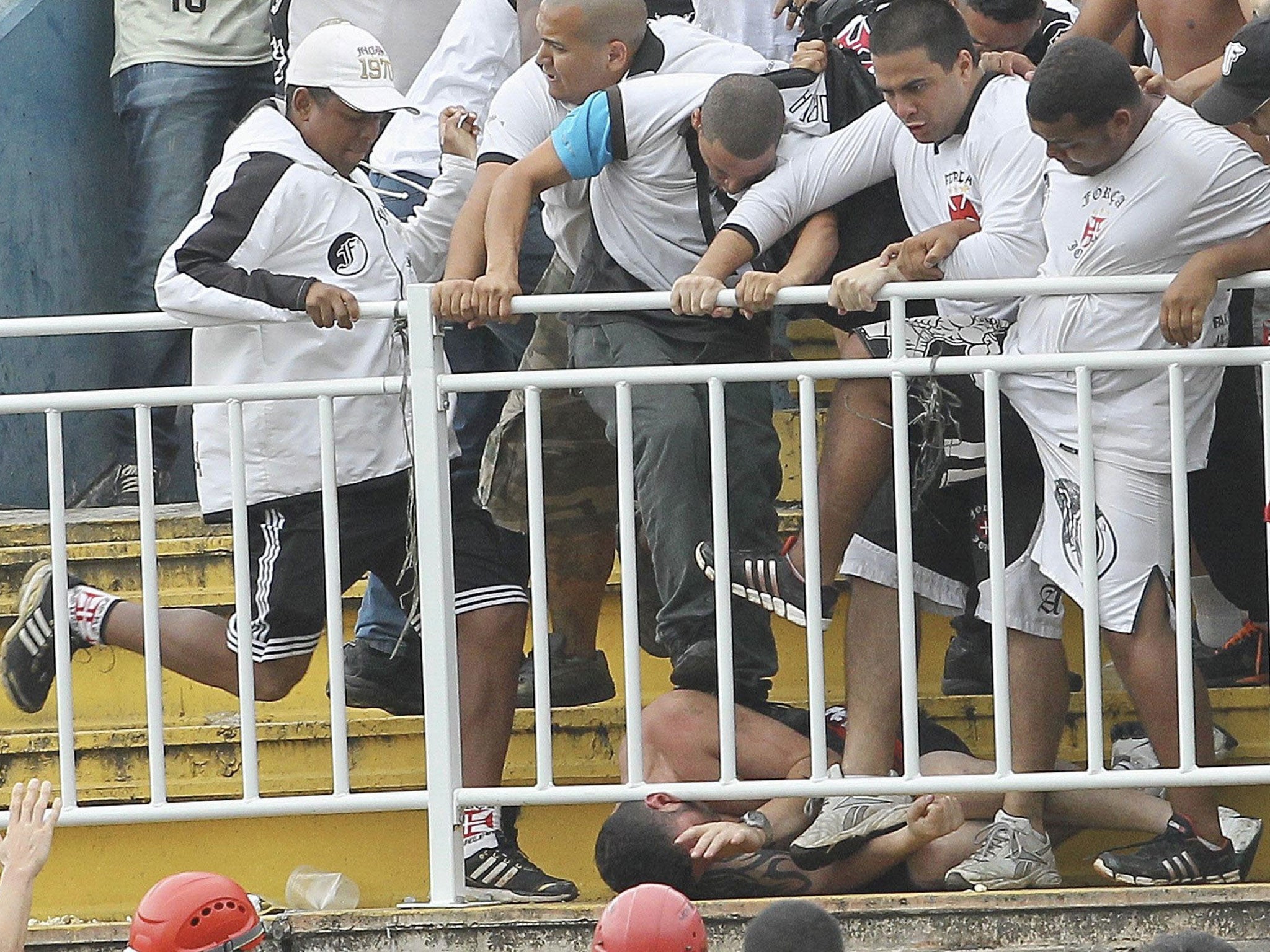 Vasco da Gama supporters attack an Atletico Paranaense fan during Sunday's game