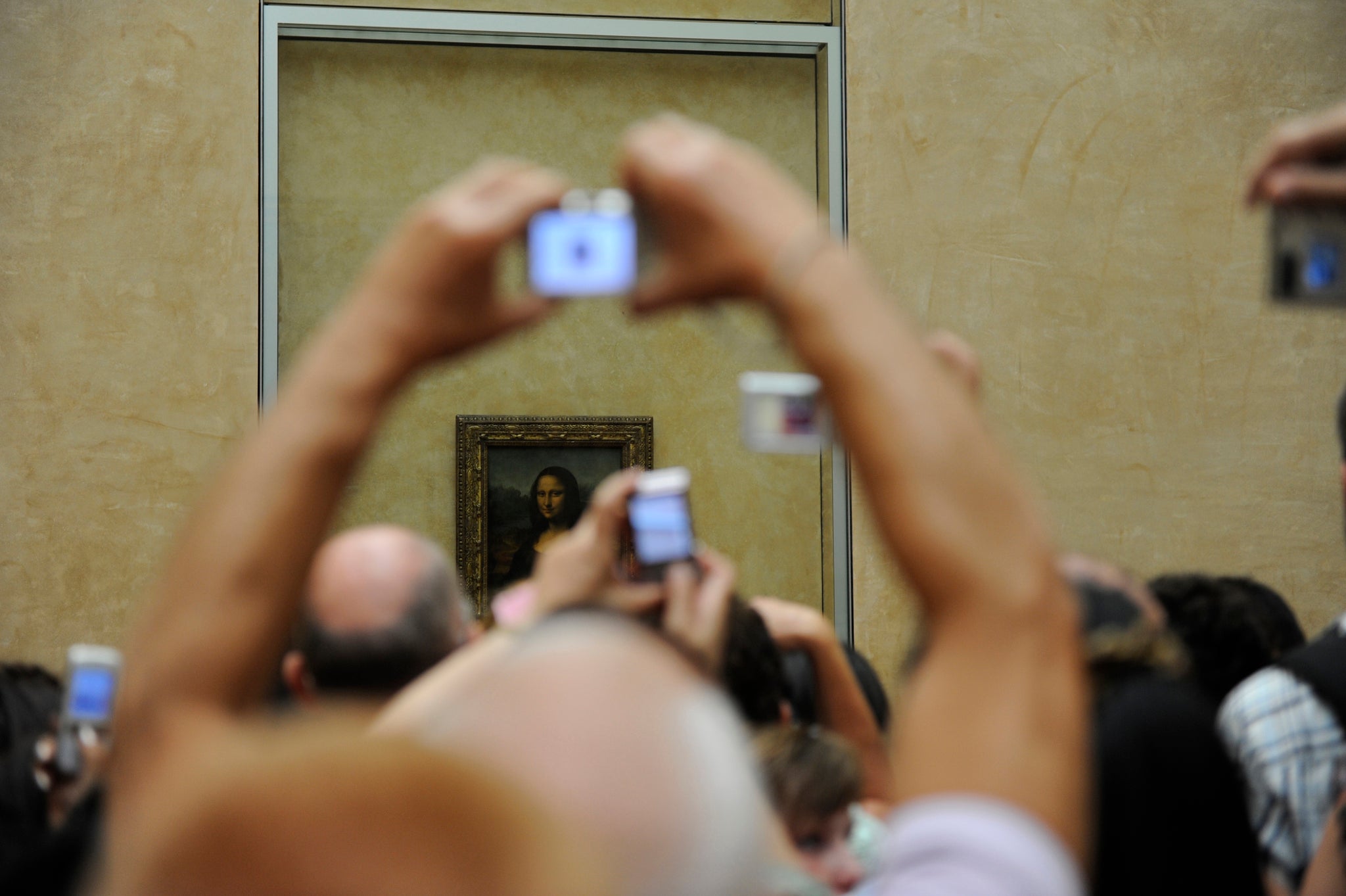 Tourists take souvenir photos of Italian painter Leonardo da Vinci's famed portrait Mona Lisa at the Louvre Museum in Paris.