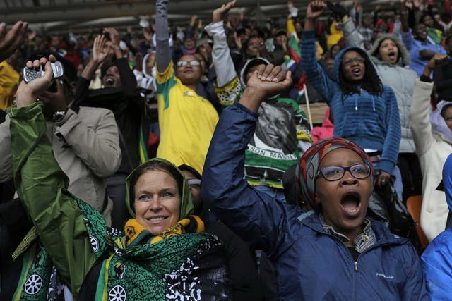 People shout out and punch the air during the memorial service for former South African president Nelson Mandela at the FNB Stadium in Soweto