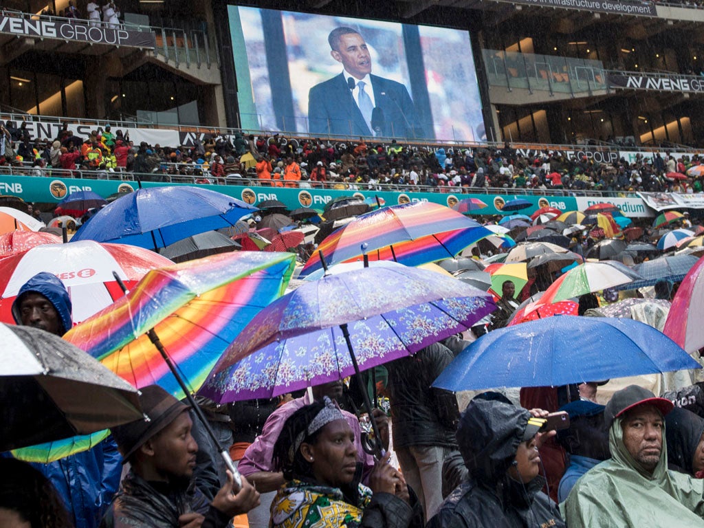 A giant screen shows US President Barack Obama delivering a speech during the memorial service for late South African President Nelson Mandela