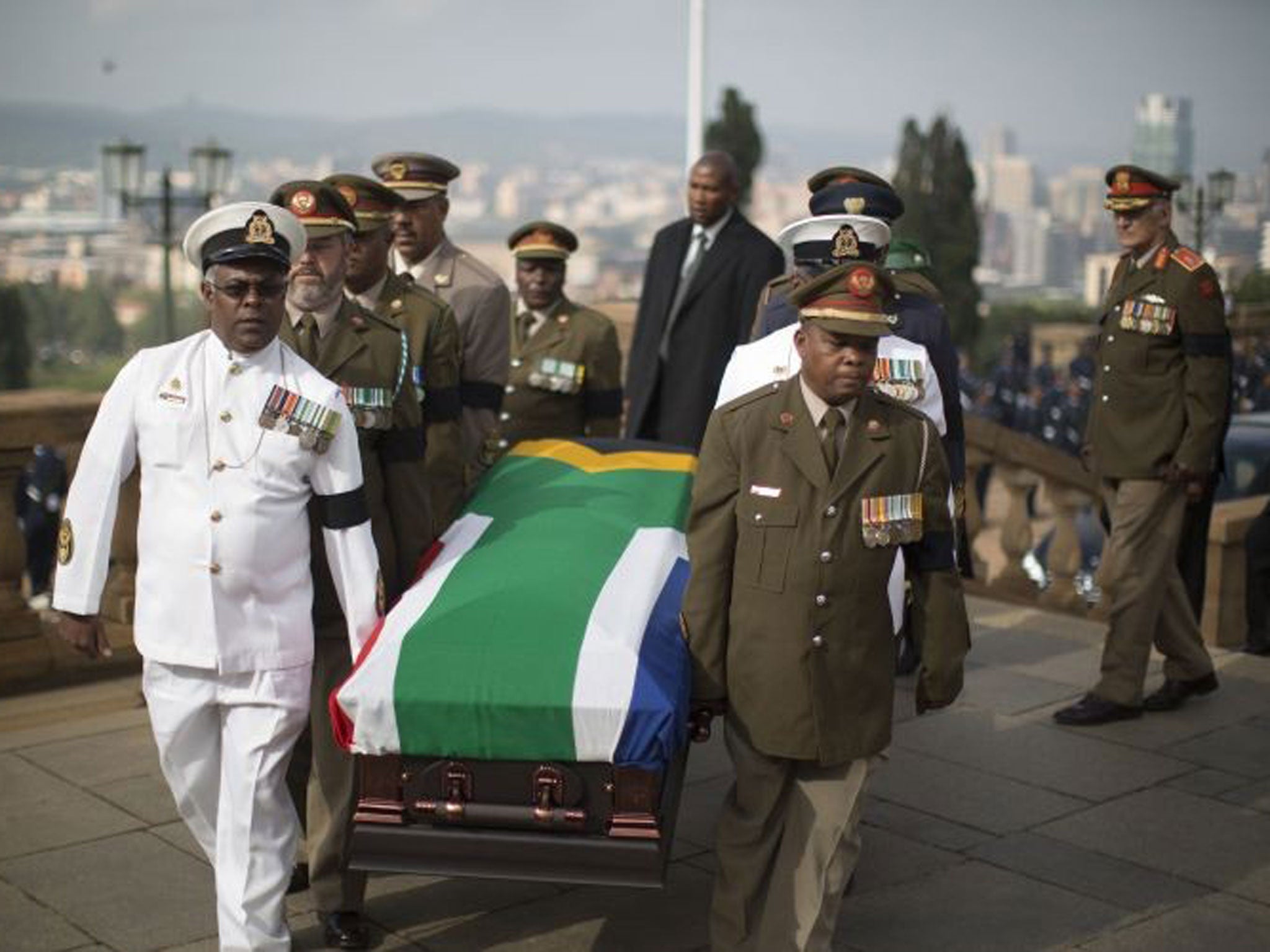 Military officers carry the coffin of South African former president Nelson Mandela to the Union Buildings marking the start of a three-day lying in state in Pretoria
