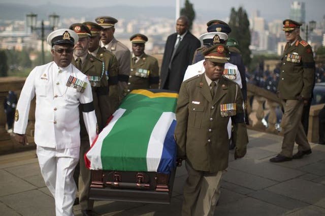 Military officers carry the coffin of South African former president Nelson Mandela to the Union Buildings marking the start of a three-day lying in state in Pretoria