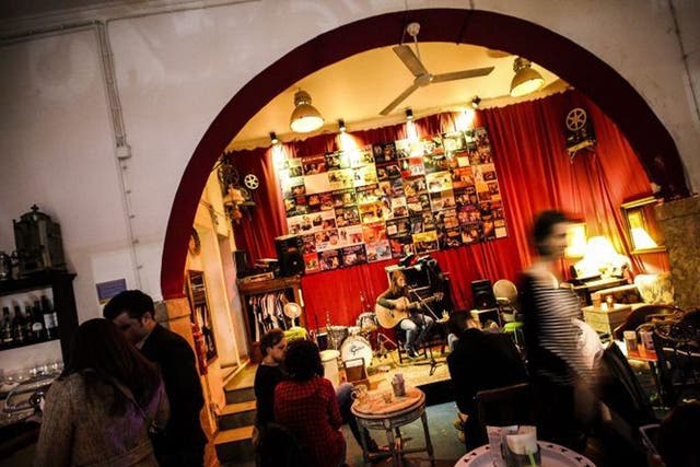 People talk and listen to live music in a bar of the Bairro Alto district of Lisbon, Portugal