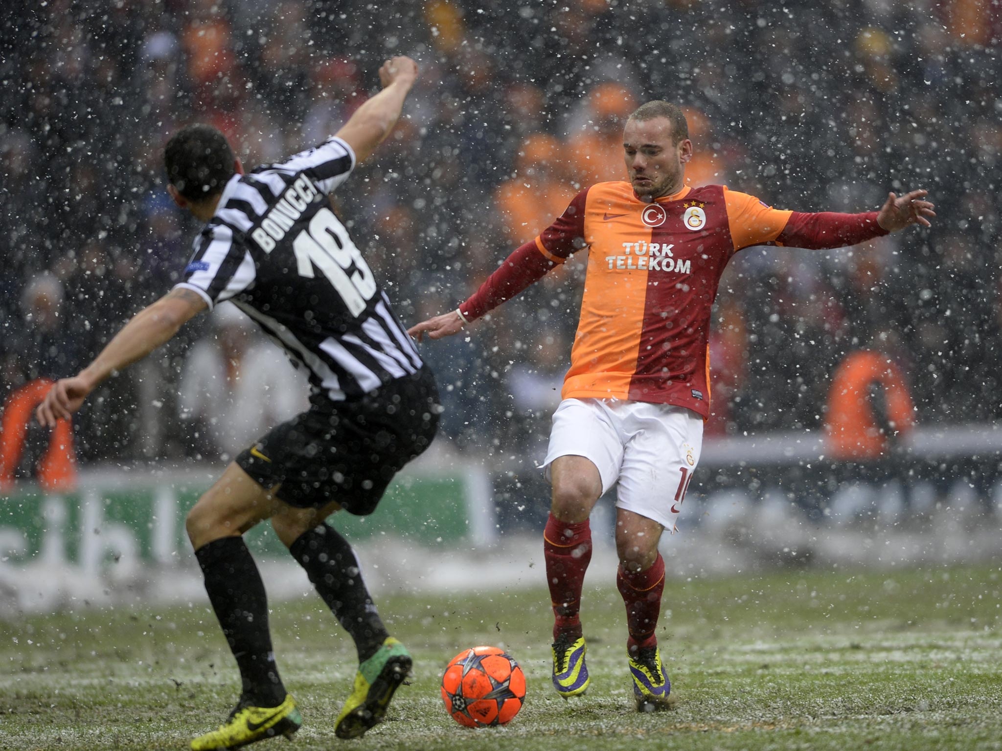 Galatasaray's Wesley Sneijder (R) fights for the ball with Juventus' Leonardo Banucci