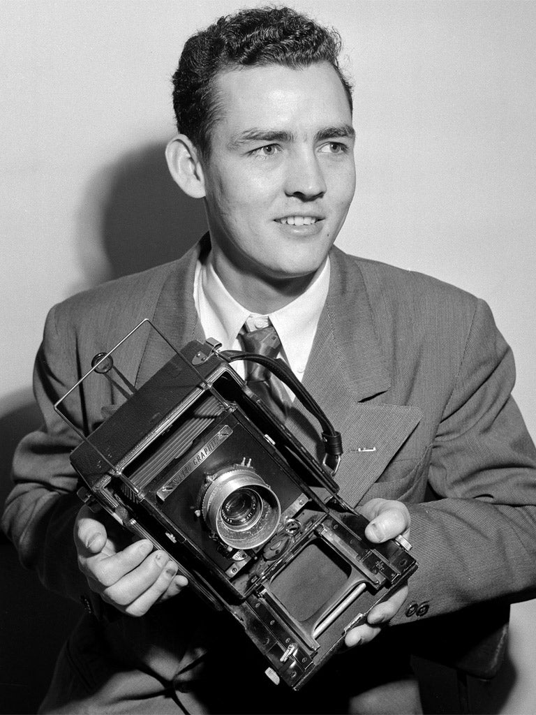 Waters poses with a Speed Graphic press camera in 1952