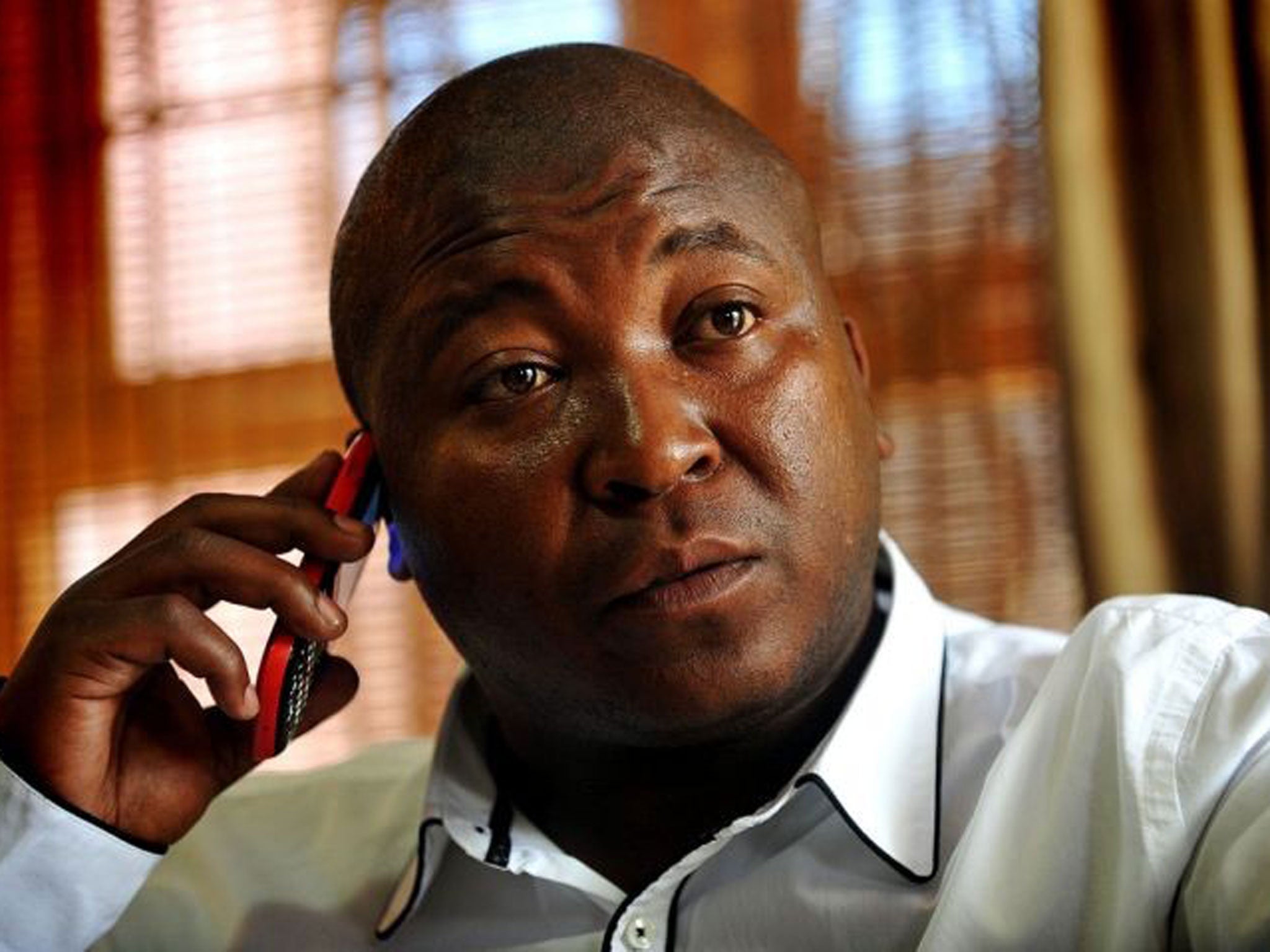 Sign language interpreter Thamsanqa Jantjie speaks on the phone at his home in Bramfischerville, South Africa