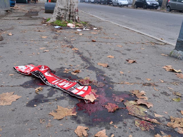An AC Milan v Ajax scarf is left in a pool of blood left after violent clashes between fans of the two clubs