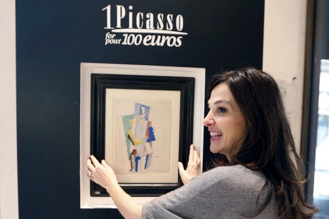 Peri Cochin, organiser of the raffle 'One Picasso for 100 Euros', stands in front of the goauche 'L'Homme au Gibus, 1914' (Man with Opera Hat) by painter Pablo Picasso