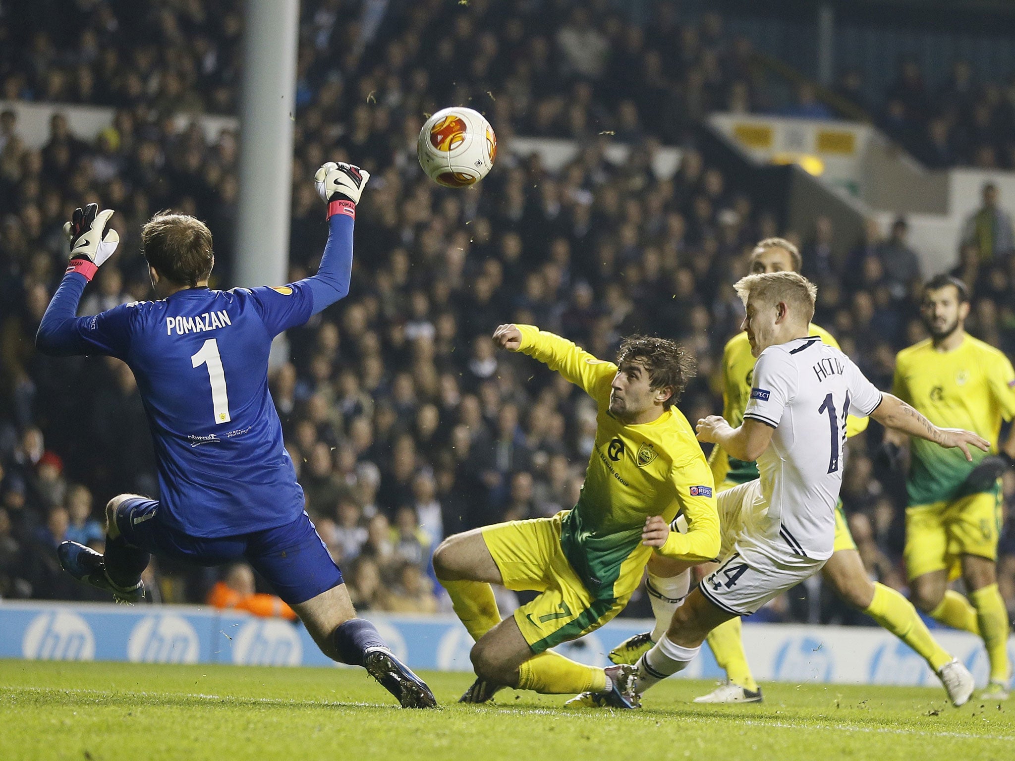 Tottenham's Lewis Holtby, right, scores a goal past Anzhi's goalkeeper Evgeni Pomazan