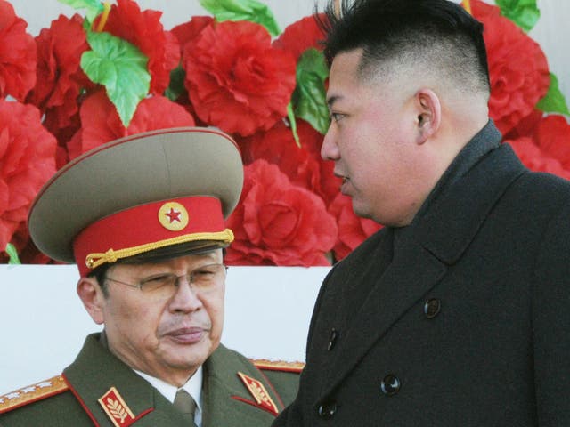 North Korean leader Kim Jong Un walks past his uncle Jang Song Thaek -  Jang was executed for 'attempting to overthrow the state' 