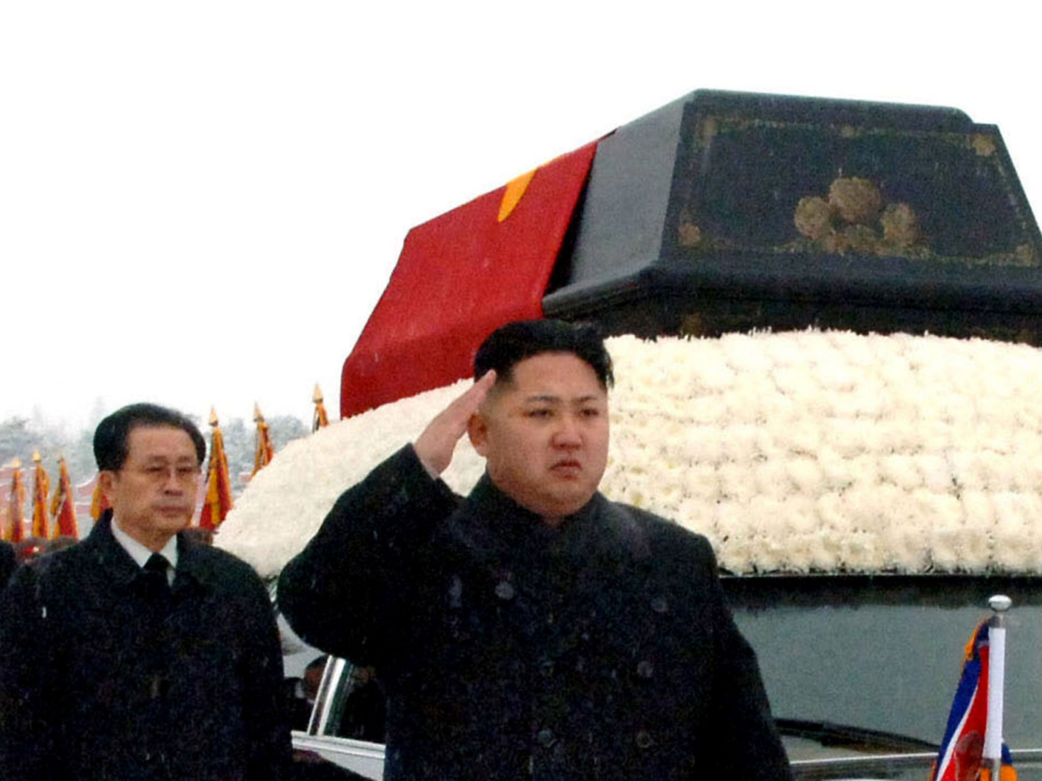 North Korea's Kim Jong Un, front, salutes beside the hearse carrying the body of his late father and then North Korean leader Kim Jong Il during the funeral procession in Pyongyang, North Korea as Jang Song Thaek follows