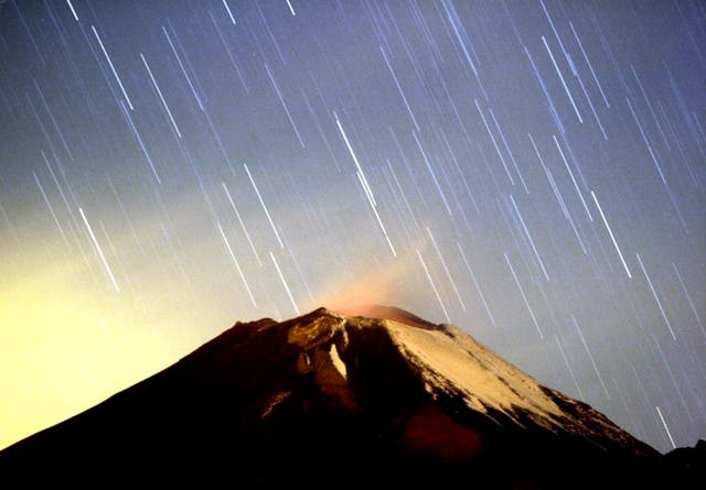 A meteor shower lights up the sky over the Mexican volcano Popocatepetl near the village San Nicolas de los Ranchos in Mexican state of Puebla in the early hours of December 14, 2004. The shower, named Geminid because it appears to originate from the constellation Gemini, lit up the sky with dozens of shooting stars per hour.