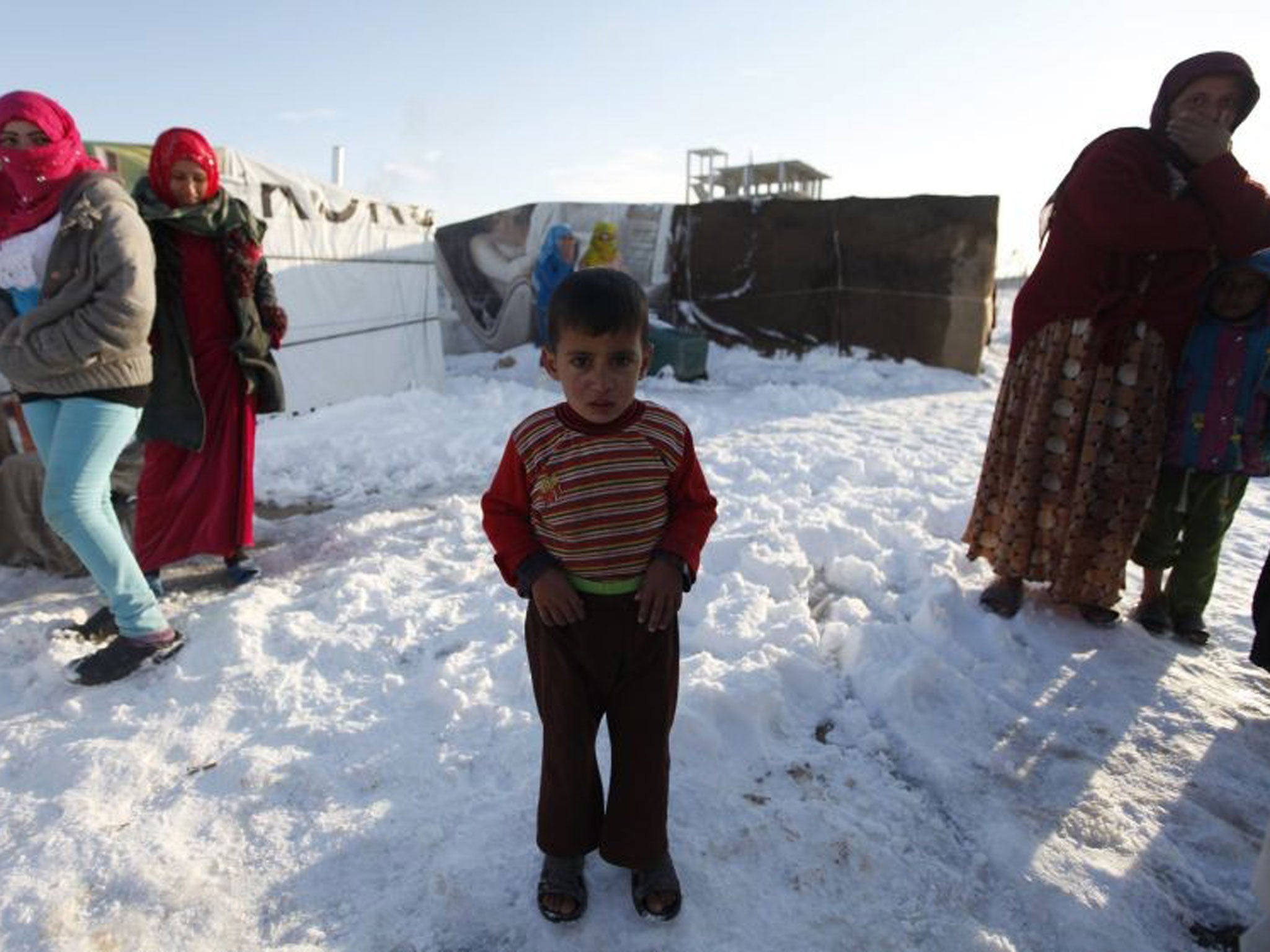 A child refugee from the northern province of Raqqa in Syria, reacts from the cold weather in a Syrian refugee camp beside the Lebanese border town of Arsal, in eastern Bekaa Valley