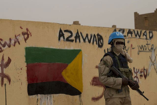  In this Sunday, July, 28, 2013 file photo, a United Nations peacekeeper stands guard at the entrance to a polling station covered in separatist flags and graffiti supporting the creation of the independent state of Azawad, in Kidal, Mali. A bomb explosio