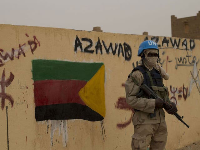  In this Sunday, July, 28, 2013 file photo, a United Nations peacekeeper stands guard at the entrance to a polling station covered in separatist flags and graffiti supporting the creation of the independent state of Azawad, in Kidal, Mali. A bomb explosio