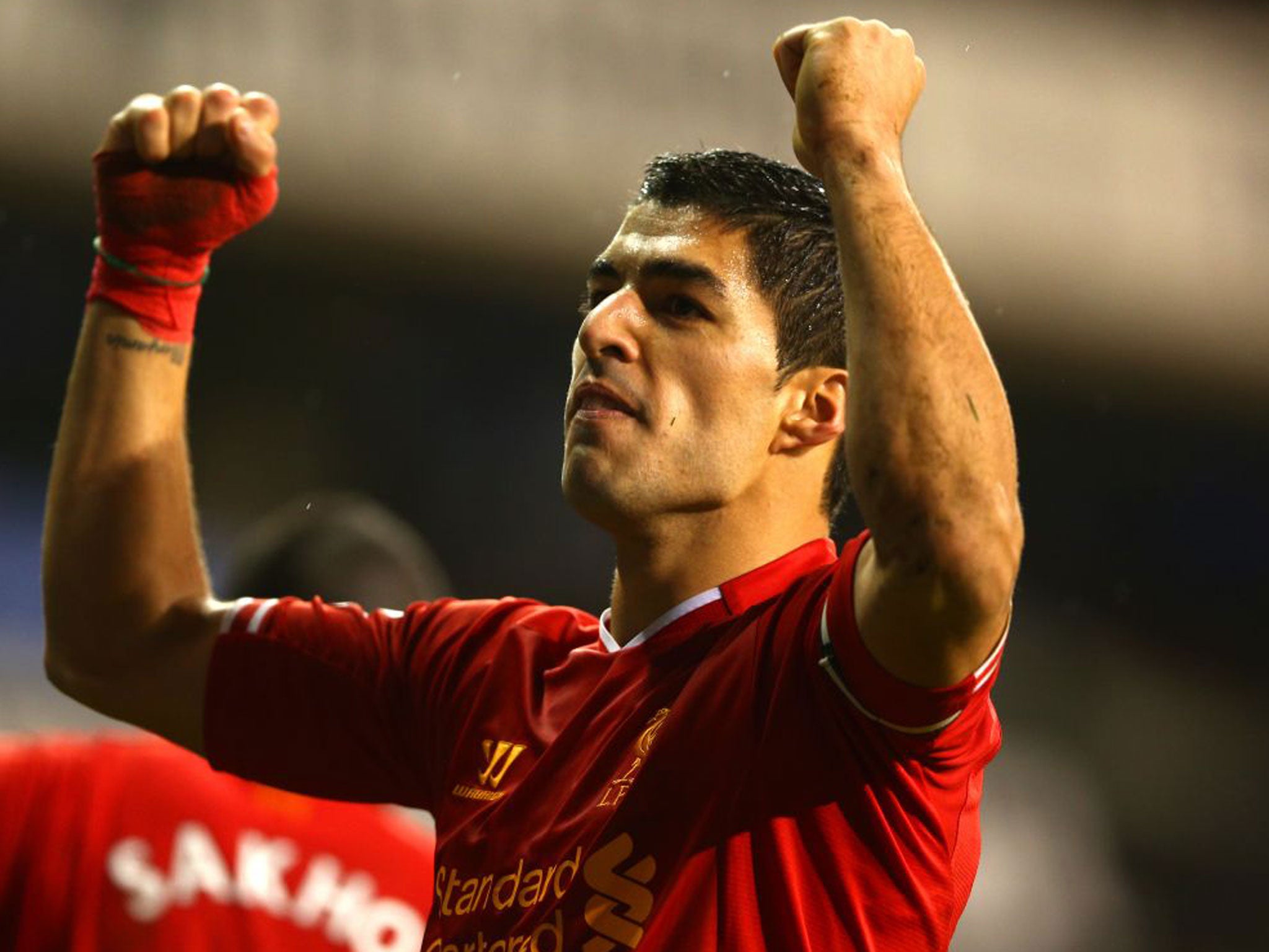 Luis Suarez celebrates his second and Liverpool's fourth against Tottenham