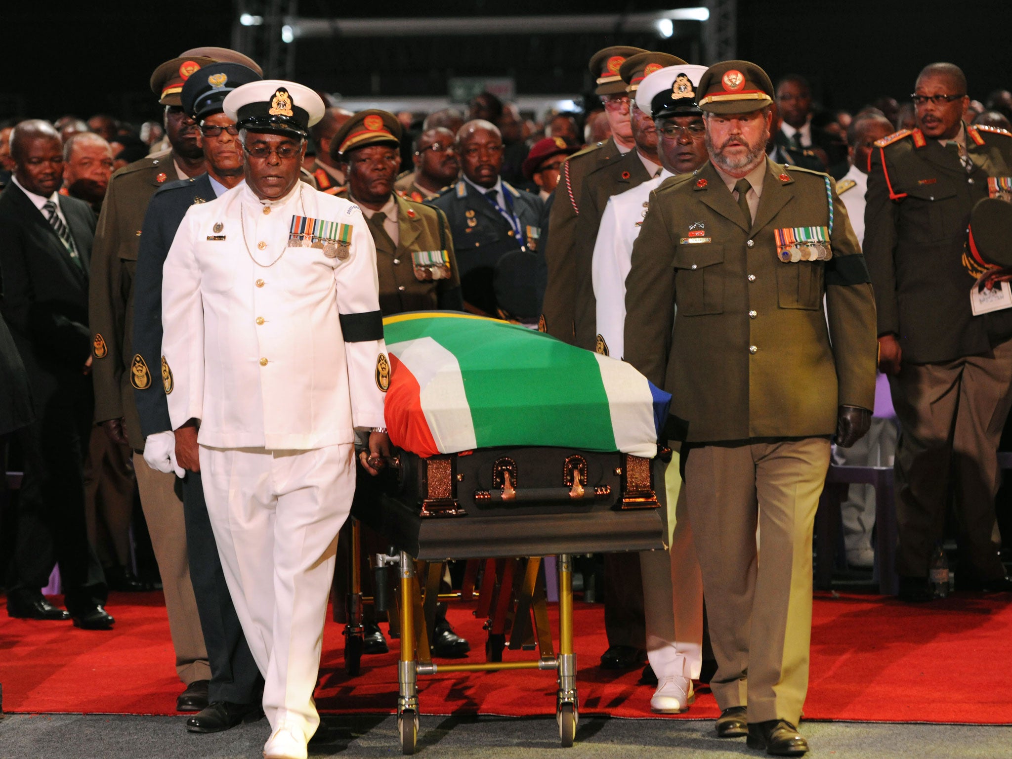 Former South African President Nelson Mandela's casket is taken out of the makeshift tent by military pall bearers following his funeral service in Qunu, South Africa
