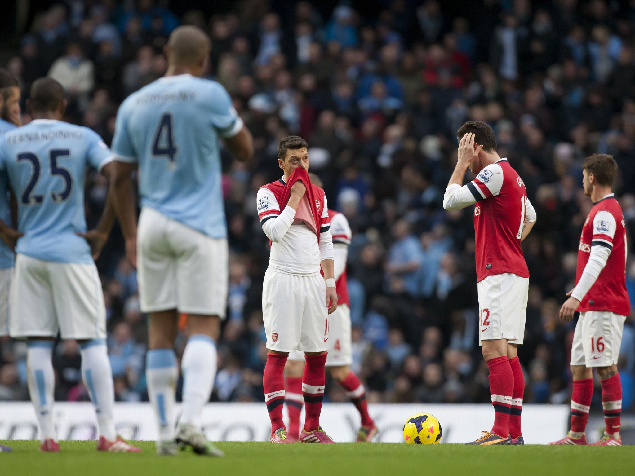 Arsenal's Mesut Özil (centre) looks downcast after Manchester City's fourth goal