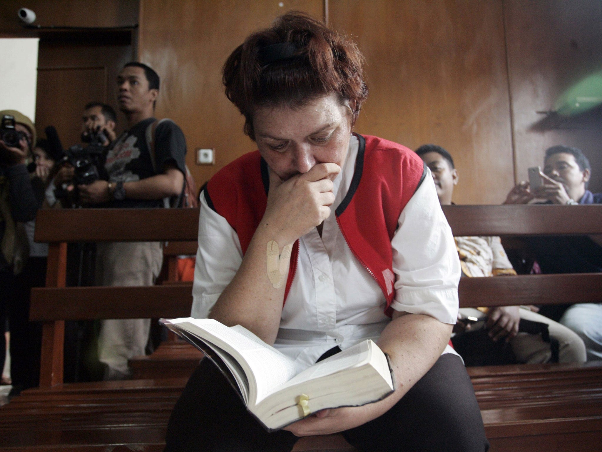 British national Andrea Waldeck reads a bible as she sits in a courtroom in Surabaya, Indonesia