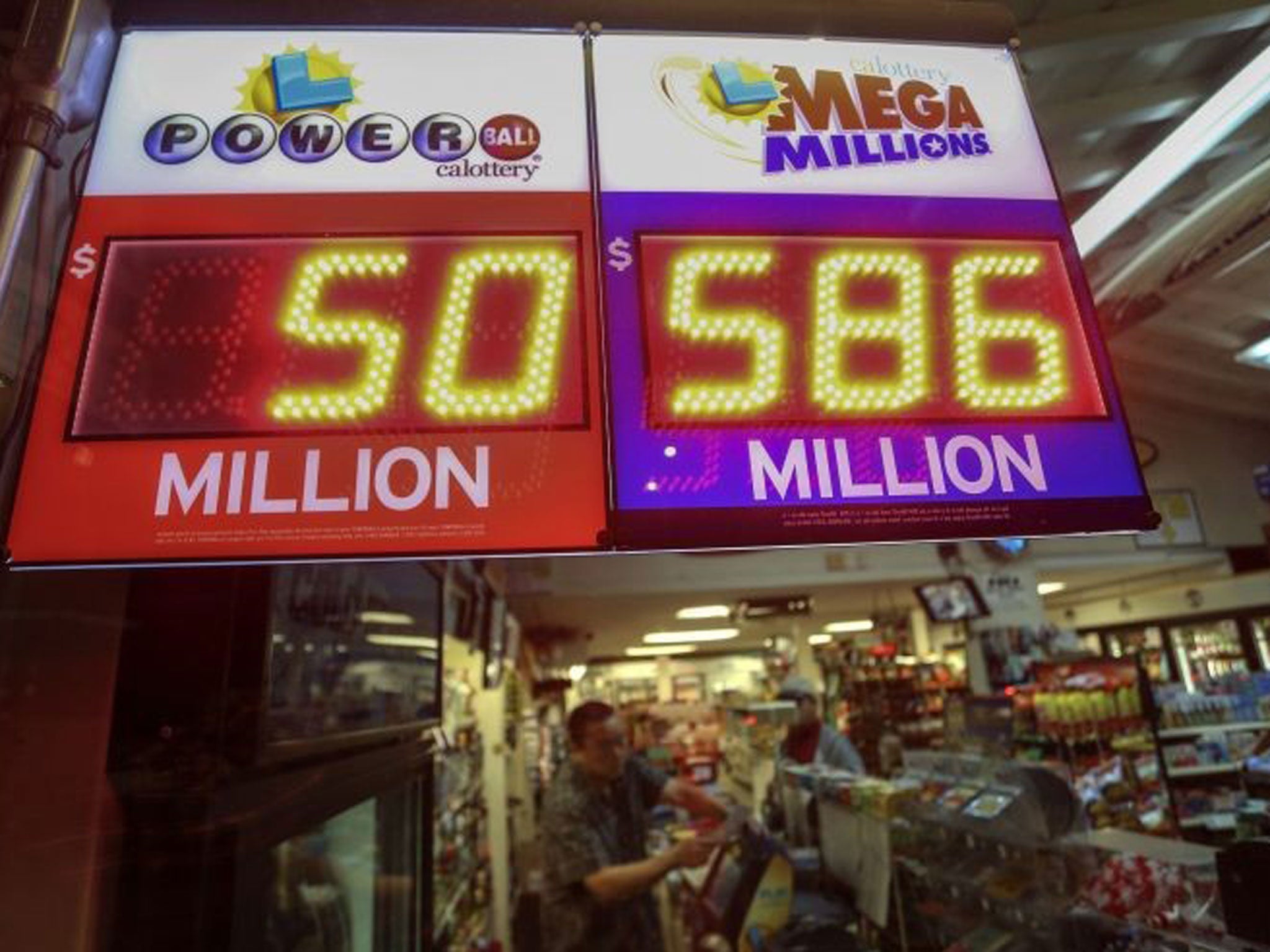A worker at Nick's Liquor Store sells lottery tickets as a sign shows the Mega Millions jackpot estimated at $586 million in Venice, California December 16, 2013. The U.S. Mega Millions jackpot has grown to an estimated $586 million making it the second-l