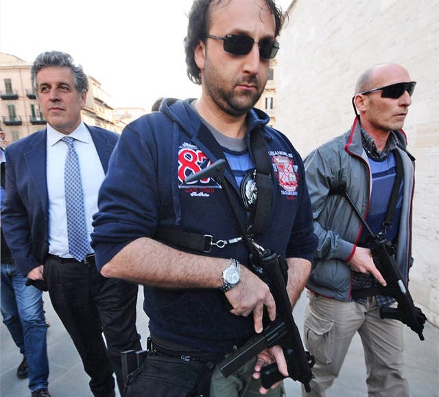 Nino Di Matteo (on left) in Palermo; he is permanently accompanied by a ring of armed carabinieri following threats made against him by a Mafia boss