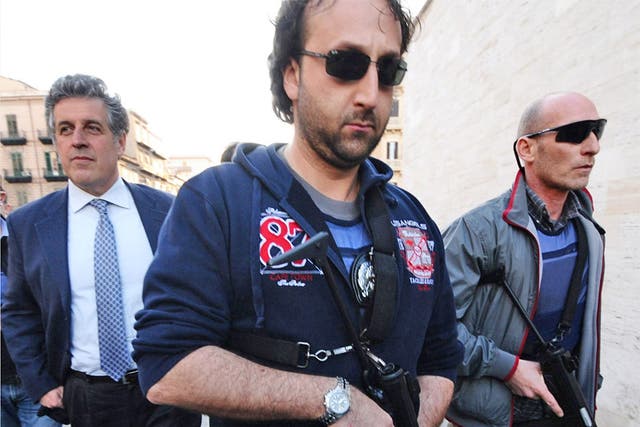 Nino Di Matteo (on left) in Palermo; he is permanently accompanied by a ring of armed carabinieri following threats made against him by a Mafia boss