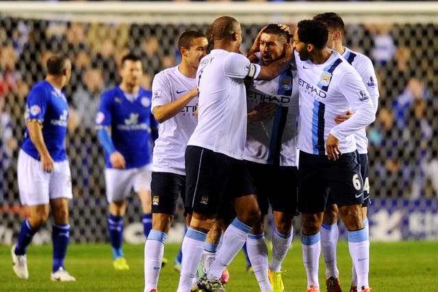 Aleksandar Kolarov of Manchester City (2R) celebrates with team mates as he scores their first goal during the Capital One Cup against Leicester