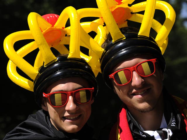 File: A pair of Belgians wearing glasses and hats in the colours of the Belgian flag pose on Belgian National day on 21 July