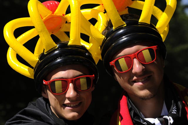 File: A pair of Belgians wearing glasses and hats in the colours of the Belgian flag pose on Belgian National day on 21 July