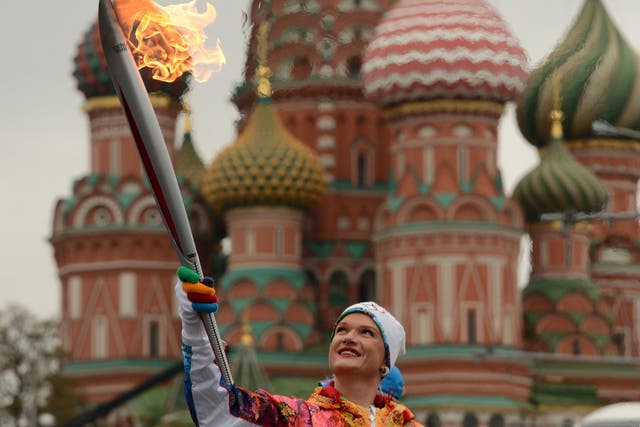 Olympic champion in gymnastics, Svetlana Khorkina, carries the Olympic torch in front of St.Basil's cathedral just outside the Red Square in Moscow