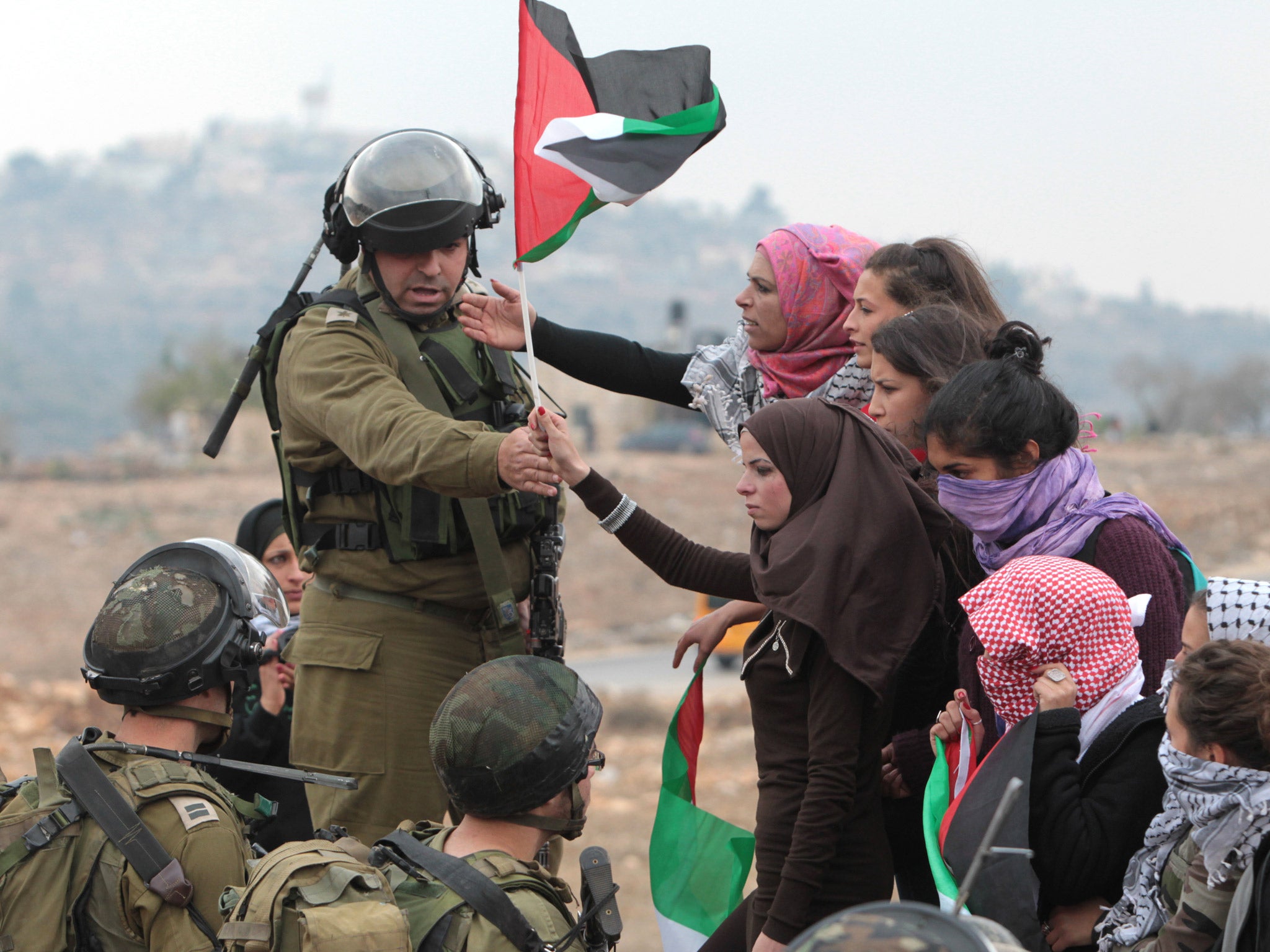 An Israeli soldier gestures to female protesters to move away during a demonstration against the building of a Jewish settlement in the West Bank, earlier this month