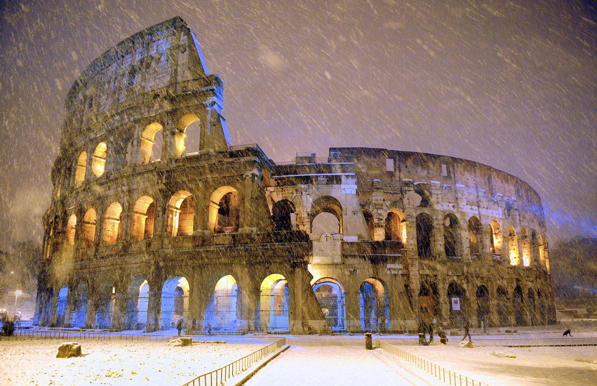 A rare snow shower falls on Rome's Colosseum, built 2,000 years ago to host gladiator duels, battle reenactments, and other public spectacles. Today the 50,000-seat amphitheater serves Rome in another capacity: as a major tourist attraction