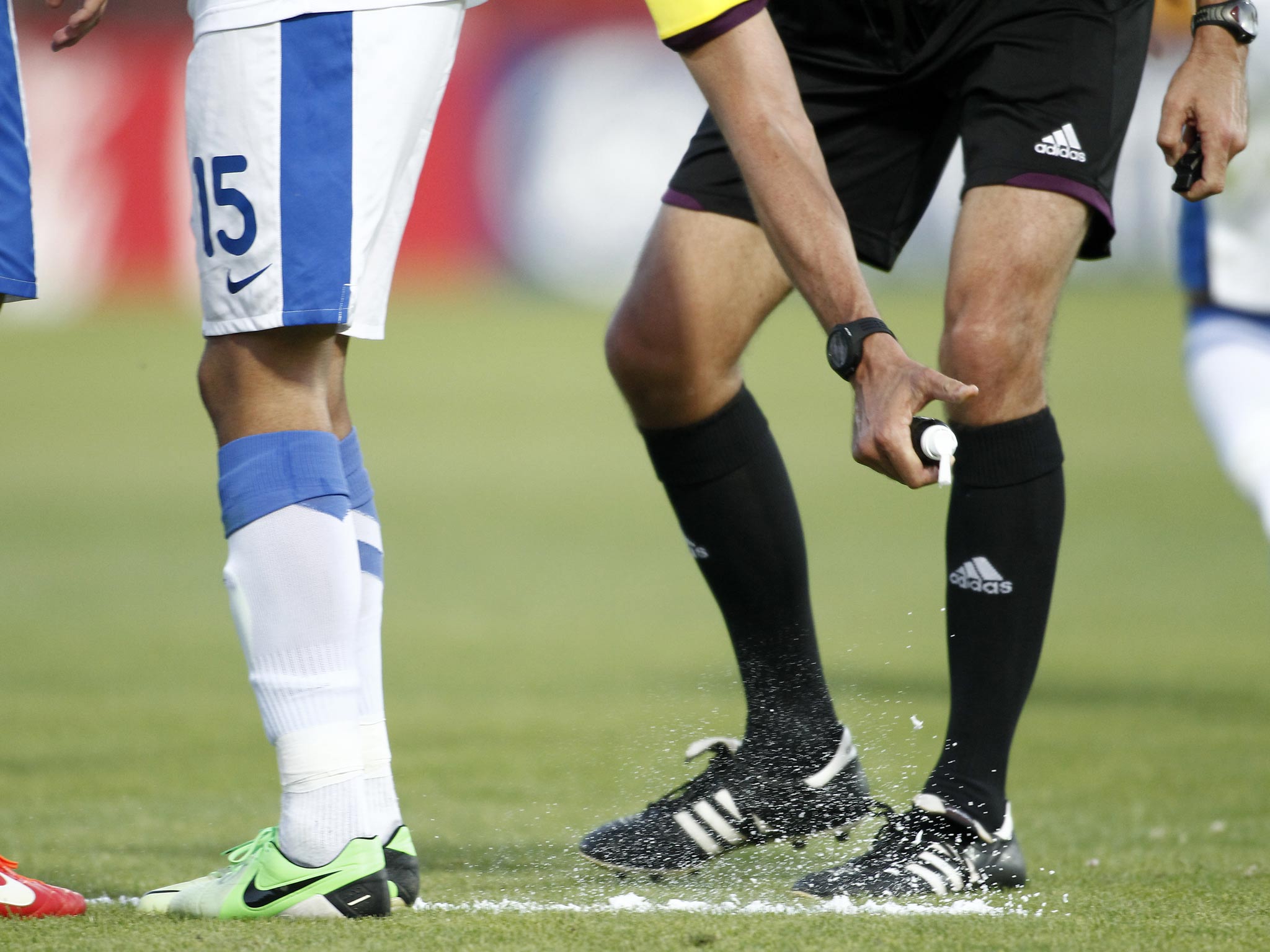 A referee uses vanishing spray