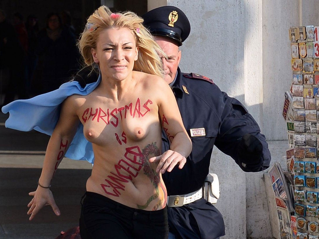 Inna Shevchenko, leader of the Ukrainian feminist protest group Femen is chased by a policeman outside Saint Peter's Square in the Vatican. Femen activists started an international topless marathon to protest against the Catholic church's views on abortion