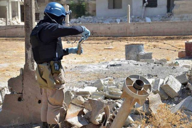 Flashback to August 2013: member  of UN investigation team taking samples of sands near a part of a missile in the Damascus countryside