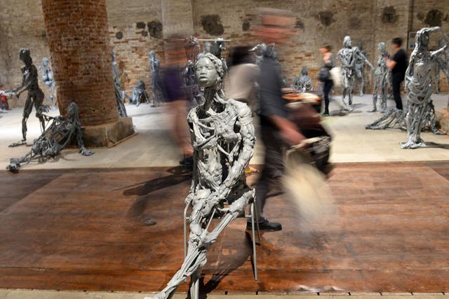 Visitors walk in the Encyclopedic Palace exhibition during the press preview of the 55th Venice art biennale