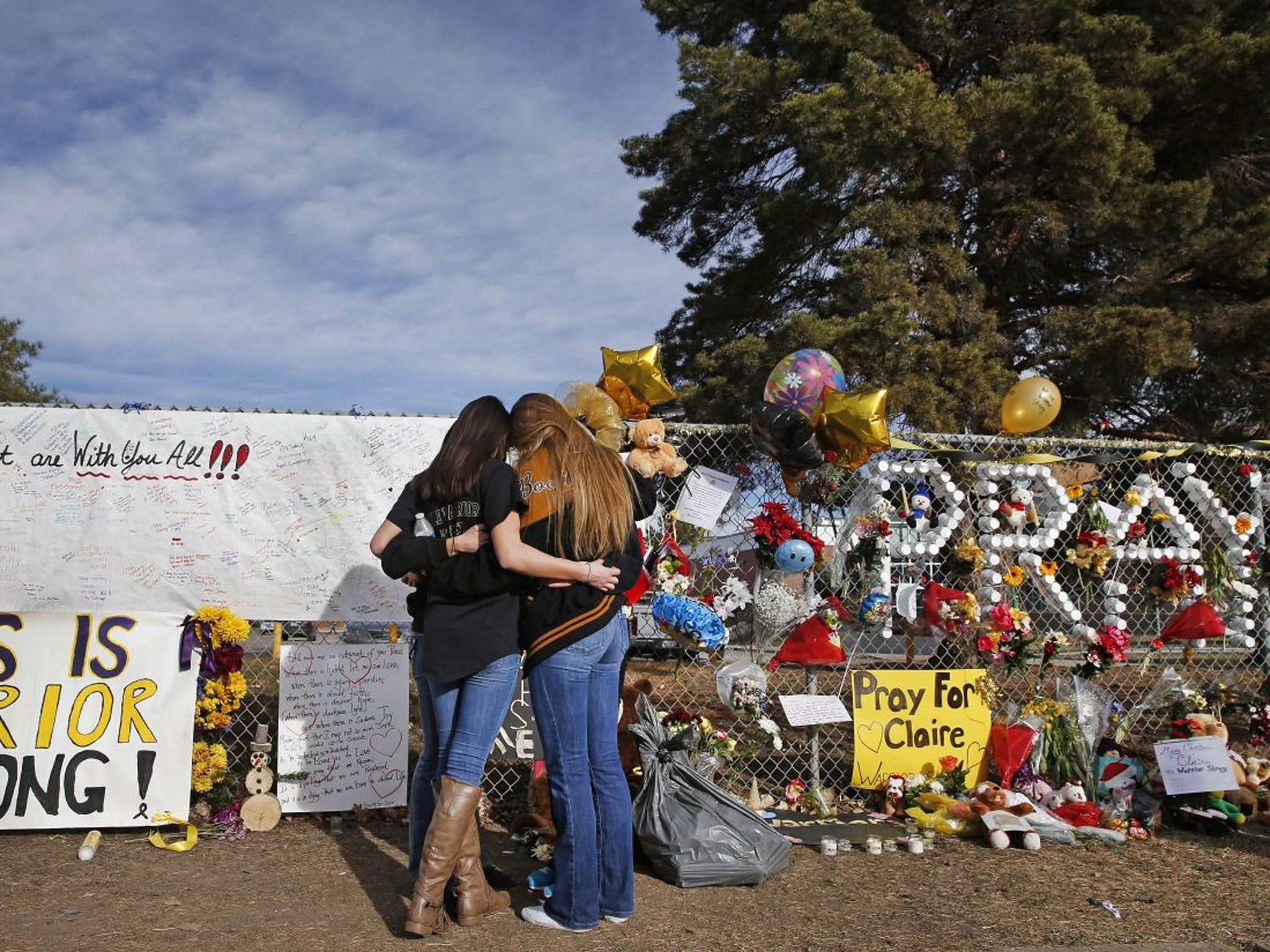 Arapahoe High School students hug at a tribute site for severely wounded student Claire Davis, who was shot by a classmate during a school attack six days earlier at Arapahoe High School, in Centennial, Colo., Thursday 19 December