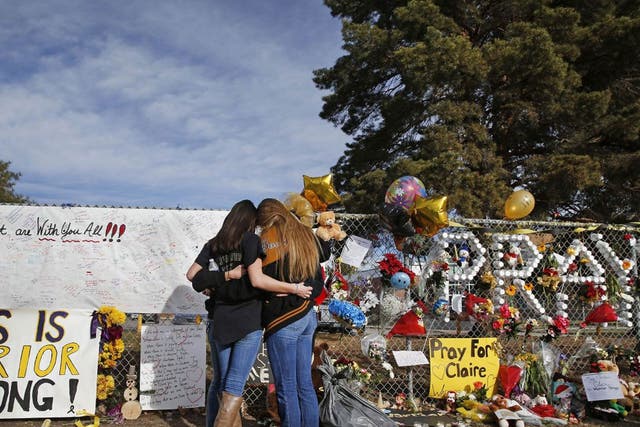 Arapahoe High School students hug at a tribute site for severely wounded student Claire Davis, who was shot by a classmate during a school attack six days earlier at Arapahoe High School, in Centennial, Colo., Thursday 19 December 