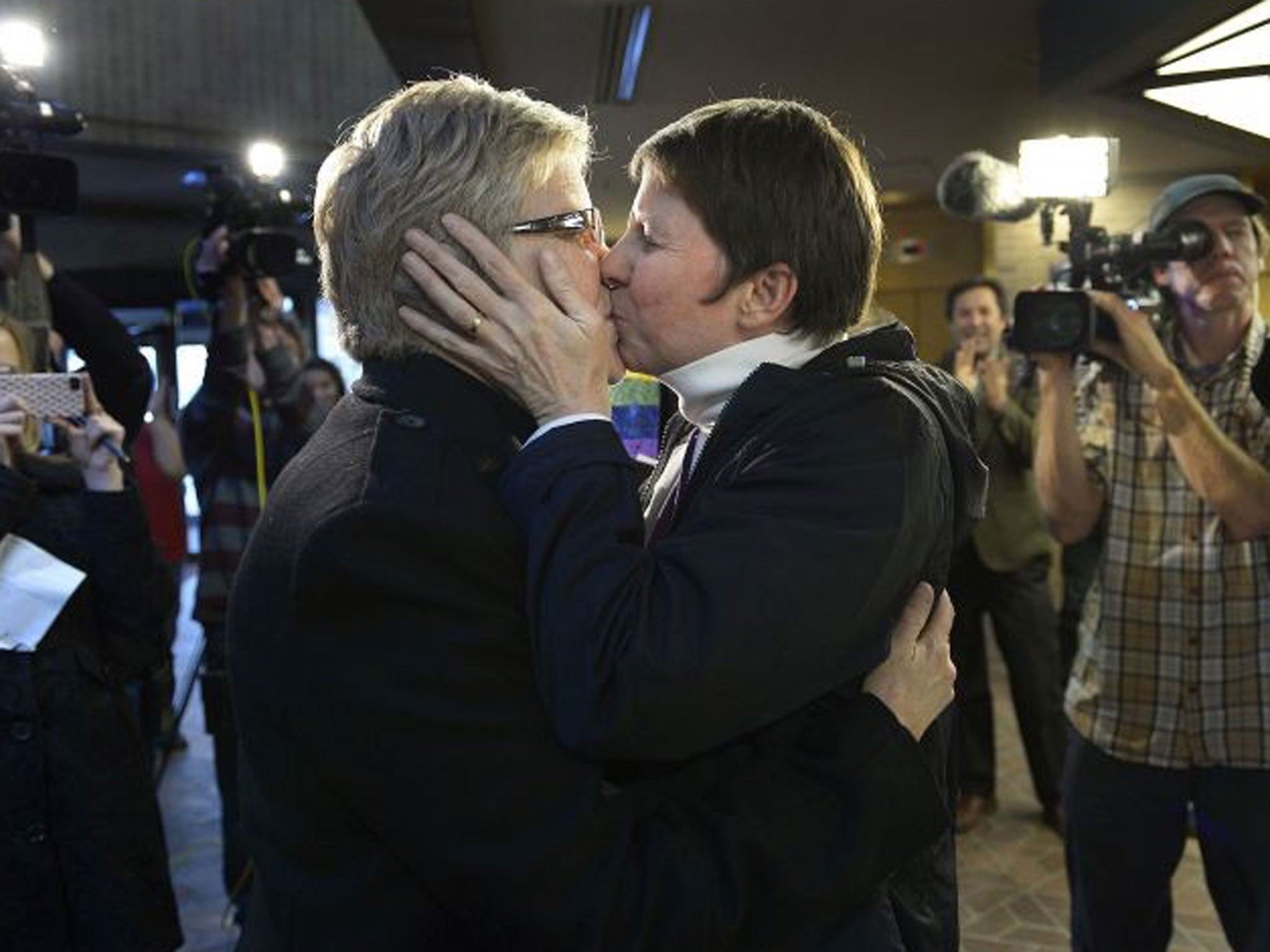 Laurie Wood, left, and Kody Partridge, kiss after being told they are officially married by the Rev. Curtis L. Price in the lobby of the Salt Lake County offices, Friday, December 20, 2013, in Salt Lake City.
