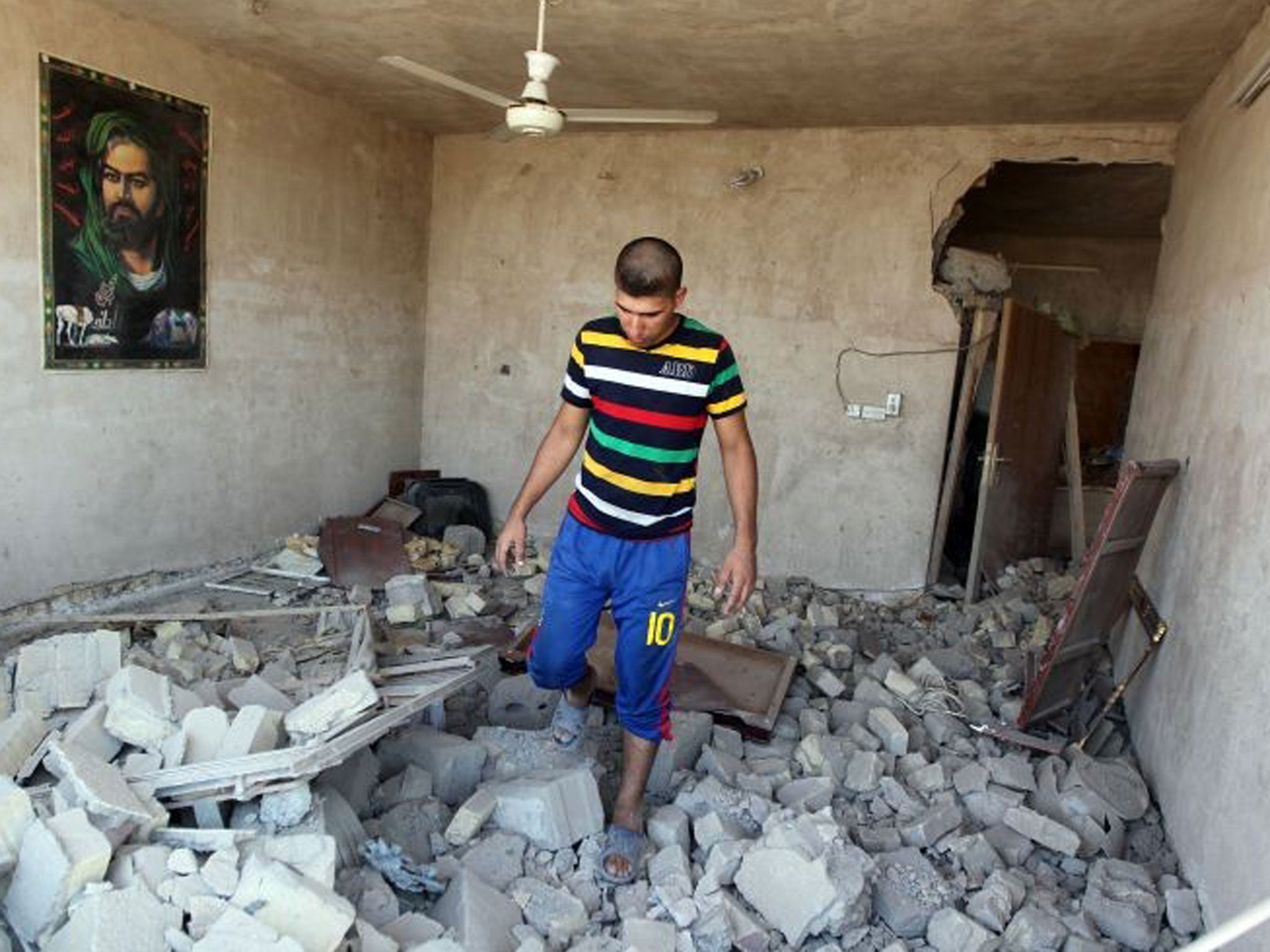 Back in business: A man in Taji, Iraq, sifts through rubble during a series of al-Qa’ida bombs that killed 42